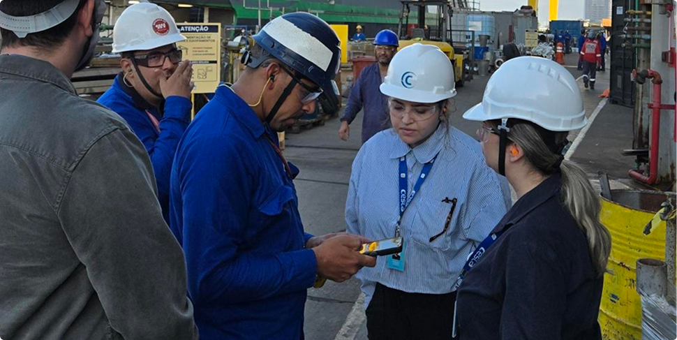 Fabiana conduzindo pesquisa de campo com operadores em planta industrial